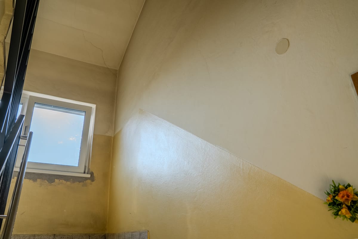 Stiegenhaus vor der Sanierung mit vergilbtem Altanstrich