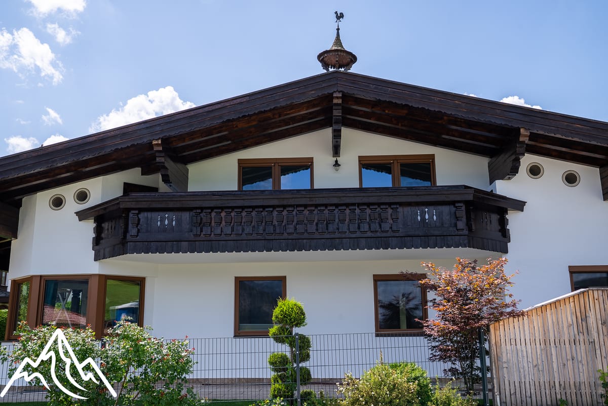 Fertige weiße Fassade eines Tiroler Landhauses mit Holzbalkon