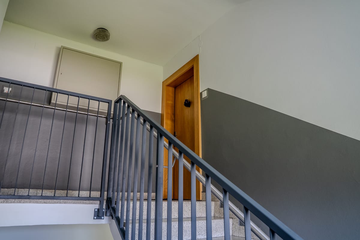 Saniertes Stiegenhaus einer Wohnanlage mit Treppenlauf und Geländer